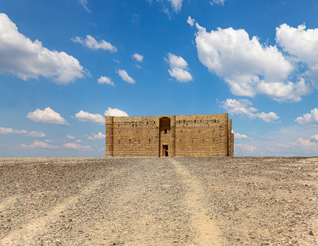 Qasr Kharana (Kharanah or Harrana)-- desert castle in eastern Jordan (100 km of Amman). Built in 8th century AD to be used as caravanserai, a resting place for traders. Against the sky with cloudsの写真素材