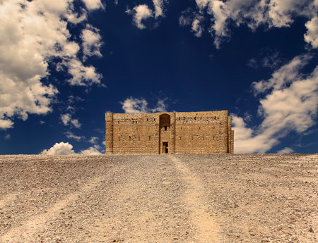 Qasr Kharana (Kharanah or Harrana)-- desert castle in eastern Jordan (100 km of Amman). Built in 8th century AD to be used as caravanserai, a resting place for traders. Against the sky with cloudsの写真素材