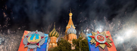 Cathedral of Intercession of Most Holy Theotokos on the Moat (Temple of Basil the Blessed) with orders of victory, and fireworks in honor of Victory Day celebration (WWII), Red Square, Moscow, Russiaの写真素材