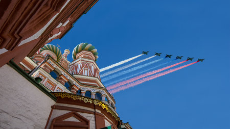 Temple of Basil the Blessed and Russian military aircraft with painted Russian flag in the sky, Air parade in honor of Victory Day celebration (WWII), Red Square, Moscow, Russiaの写真素材
