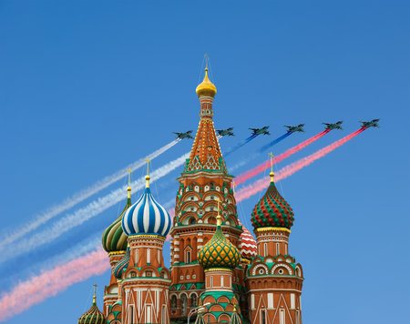 Temple of Basil the Blessed and Russian military aircraft with painted Russian flag in the sky, Air parade in honor of Victory Day celebration (WWII), Red Square, Moscow, Russiaの写真素材