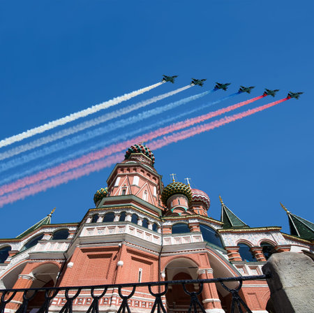 Temple of Basil the Blessed and Russian military aircraft with painted Russian flag in the sky, Air...