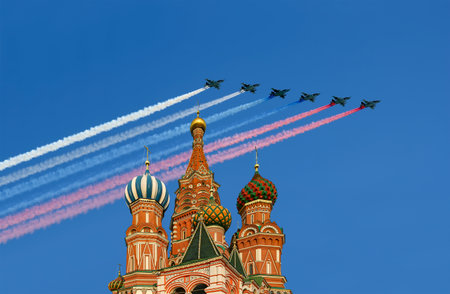 Temple of Basil the Blessed and Russian military aircraft with painted Russian flag in the sky, Air parade in honor of Victory Day celebration (WWII), Red Square, Moscow, Russiaの写真素材