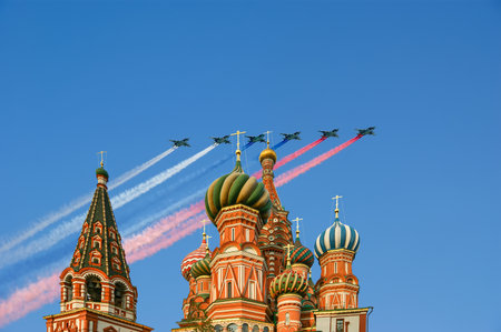 Temple of Basil the Blessed and Russian military aircraft with painted Russian flag in the sky, Air parade in honor of Victory Day celebration (WWII), Red Square, Moscow, Russiaの写真素材