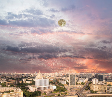 Aerial view of Moscow against the romantic evening sky with clouds and rays of the sun with the moon. Government House of the Russian Federation (White House)-written in Russian, Russiaの写真素材