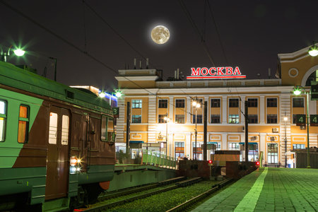 Train on Moscow passenger platform (Savelovsky railway station) with the super moon -- is one of the nine main railway stations in Moscow, Russia (at night)の写真素材