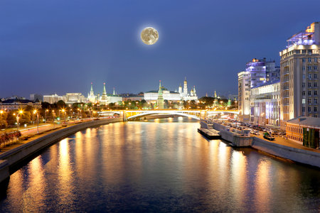 Night view of the Moskva River, the Great Stone Bridge and the Kremlin, with the moon, Moscow, Russia.の写真素材