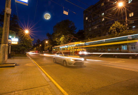Traffic of cars in Moscow city center at night, with the super moon, Russia