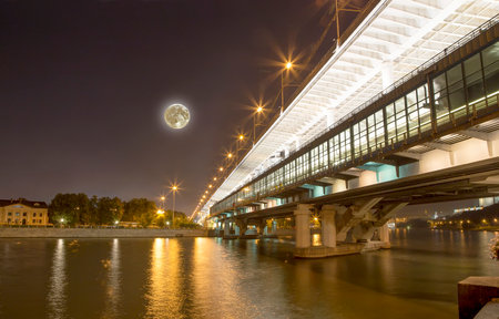 Moscow River, Luzhnetskaya Bridge (Metro Bridge) in the light of night colored lights, with the super moon. Moscow, Russiaの写真素材