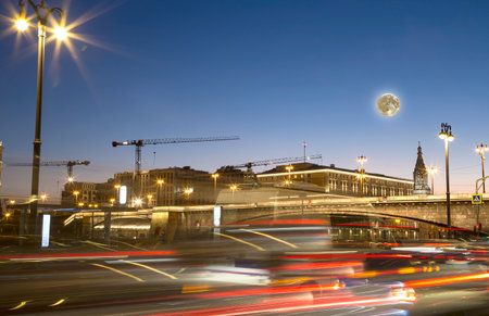 Night traffic on the Moskvoretskaya Embankment near the park Zaryadye (with the super moon), Moscow, Russiaの写真素材
