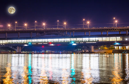 Moscow River, Luzhnetskaya Bridge (Metro Bridge) in the light of night colored lights (with the super moon). Moscow, Russiaの写真素材