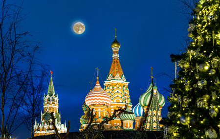 Saint Basil cathedral (Temple of Basil the Blessed), Spasskaya Tower and Christmas (New Year) decoration, Moscow, Russia. View from Zaryadye Park (at night with the super moon)の写真素材