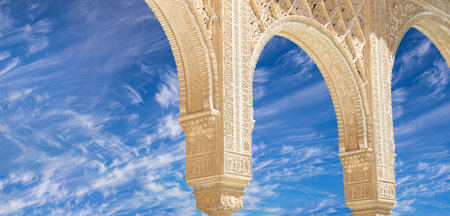 Arches in Islam (Moorish) style (against the background of a beautiful sky with clouds) in Alhambra, Granada, Spainの写真素材