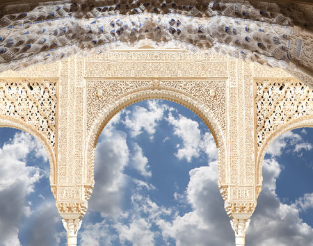 Arches in Islam (Moorish) style (against the background of a beautiful sky with clouds) in Alhambra, Granada, Spainの写真素材
