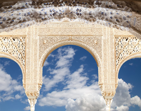 Arches in Islam (Moorish) style (against the background of a beautiful sky with clouds) in Alhambra, Granada, Spainの写真素材
