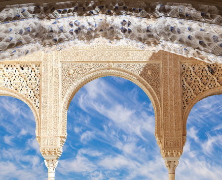 Arches in Islam (Moorish) style (against the background of a beautiful sky with clouds) in Alhambra, Granada, Spainの写真素材