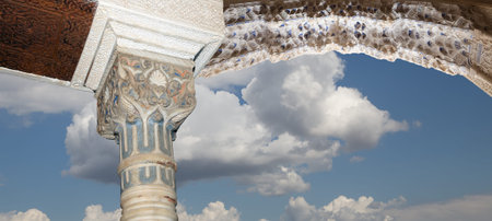 Arches in Islam (Moorish) style (against the background of a beautiful sky with clouds) in Alhambra,...
