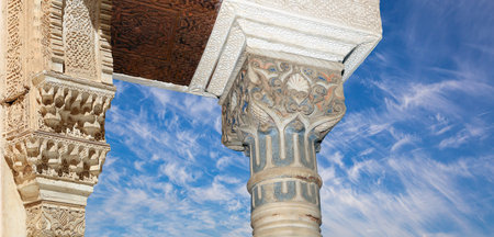 Arches in Islam (Moorish) style (against the background of a beautiful sky with clouds) in Alhambra,...