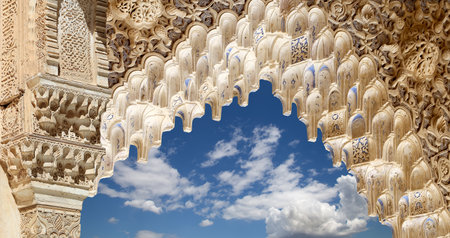 Arches in Islam (Moorish) style (against the background of a beautiful sky with clouds) in Alhambra, Granada, Spainの写真素材