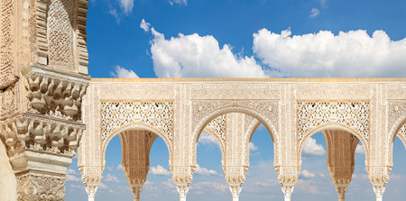 Arches in Islam (Moorish) style (against the background of a beautiful sky with clouds) in Alhambra, Granada, Spainの写真素材
