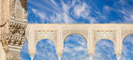 Arches in Moorish style (against the background of a beautiful sky with clouds) in Alhambra,...
