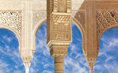 Arches in Islam (Moorish) style (against the background of a beautiful sky with clouds) in Alhambra, Granada, Spainの写真素材