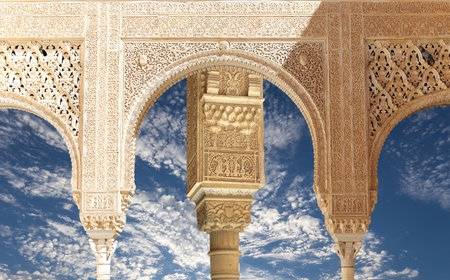 Arches in Islam (Moorish) style (against the background of a beautiful sky with clouds) in Alhambra, Granada, Spainの写真素材