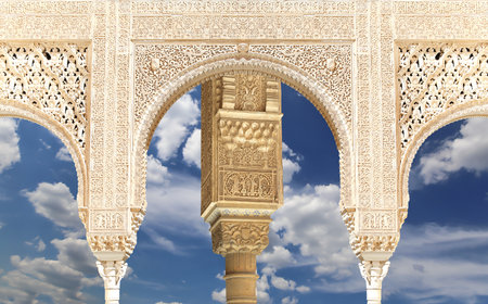 Arches in Islam (Moorish) style (against the background of a beautiful sky with clouds) in Alhambra, Granada, Spainの写真素材