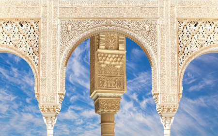 Arches in Islam (Moorish) style (against the background of a beautiful sky with clouds) in Alhambra, Granada, Spainの写真素材