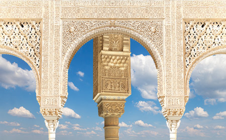 Arches in Islam (Moorish) style (against the background of a beautiful sky with clouds) in Alhambra, Granada, Spainの写真素材