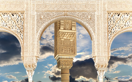 Arches in Islam (Moorish) style (against the background of a beautiful sky with clouds) in Alhambra, Granada, Spainの写真素材