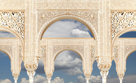 Arches in Islam (Moorish) style (against the background of a beautiful sky with clouds) in Alhambra,...