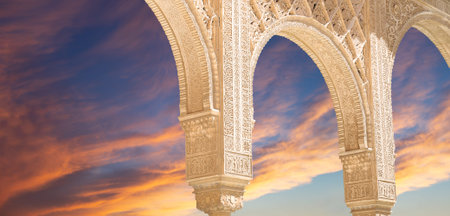 Arches in Islam (Moorish) style (against the sunset) in Alhambra, Granada, Spain