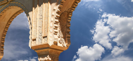 Arches in Islam (Moorish) style (against the background of a beautiful sky with clouds) in Alhambra, Granada, Spainの写真素材