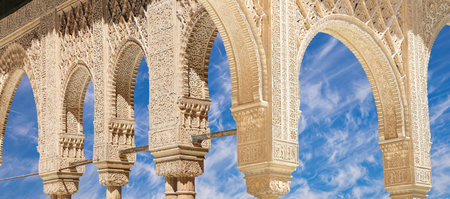 Arches in Islamic (Moorish) style (against the background of a beautiful sky with clouds) in...
