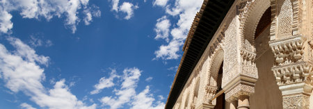 Arches in Islamic (Moorish) style (against the background of a beautiful sky with clouds) in Alhambra, Granada, Spainの写真素材