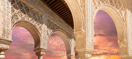 Arches in Islamic (Moorish) style (against the sunset) in Alhambra, Granada, Spain
