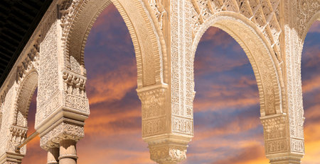 Arches in Islamic (Moorish) style (against the sunset) in Alhambra, Granada, Spain