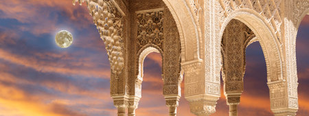 Arches in Islamic (Moorish) style (against the sunset with the super moon) in Alhambra, Granada,...