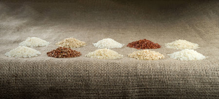Ten heaps of rice of different varieties on the background of sacking.の写真素材