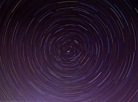 Star tracks in the night sky. Long exposure star trails. Lines of colored stars. Polar Star