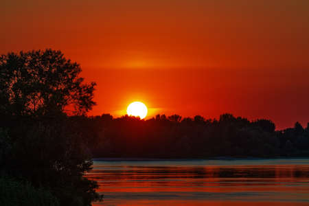 Sunset over water and trees. The Dnieper River and the nature of Ukraine. sun close upの写真素材
