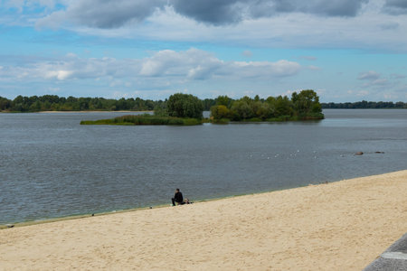 Lonely fisherman on an empty beach on the banks of the Dnieper River