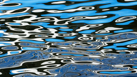 Curved white and blue lines reflected on the surface of the water. Ripples of light on the waves