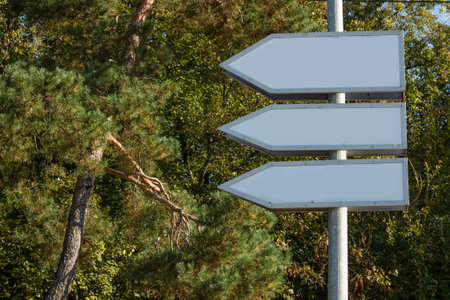 Empty street arrow pointers on a sunny day. Iron pole. Free space for text