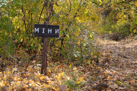 A sign with the inscription "Mines" in the forest Ukraine. Hazard warning. Sunny autumn dayの写真素材