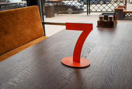 The wooden number seven is on the table. Table number 7 in a cafe or restaurantの写真素材