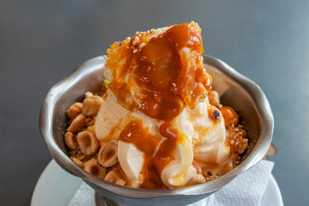 White ice cream with nuts and caramel in an iron cup close-up. natural dessertの写真素材