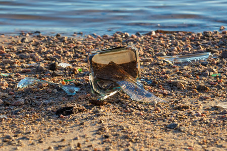 Broken glass bottle on the shore - environmental pollutionの写真素材