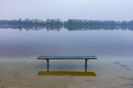 Spring flood on the river. The water level rose and flooded the bench on the shoreの写真素材